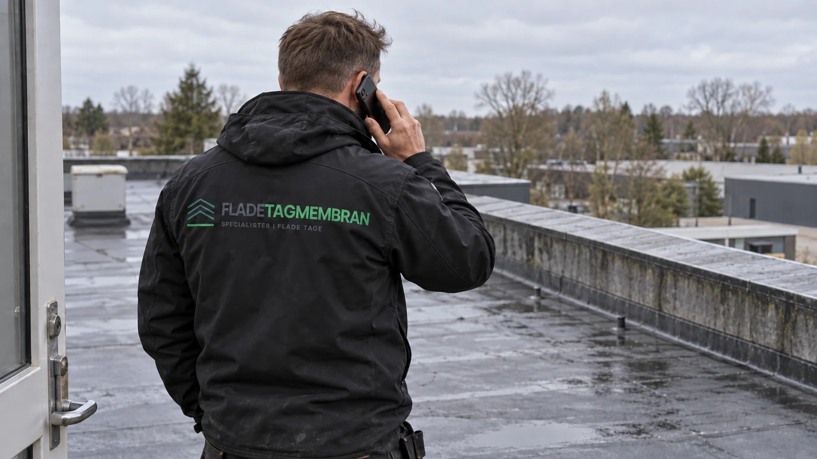 Medarbejder fra Fladetagmembran taler i telefon på et fladt tag
